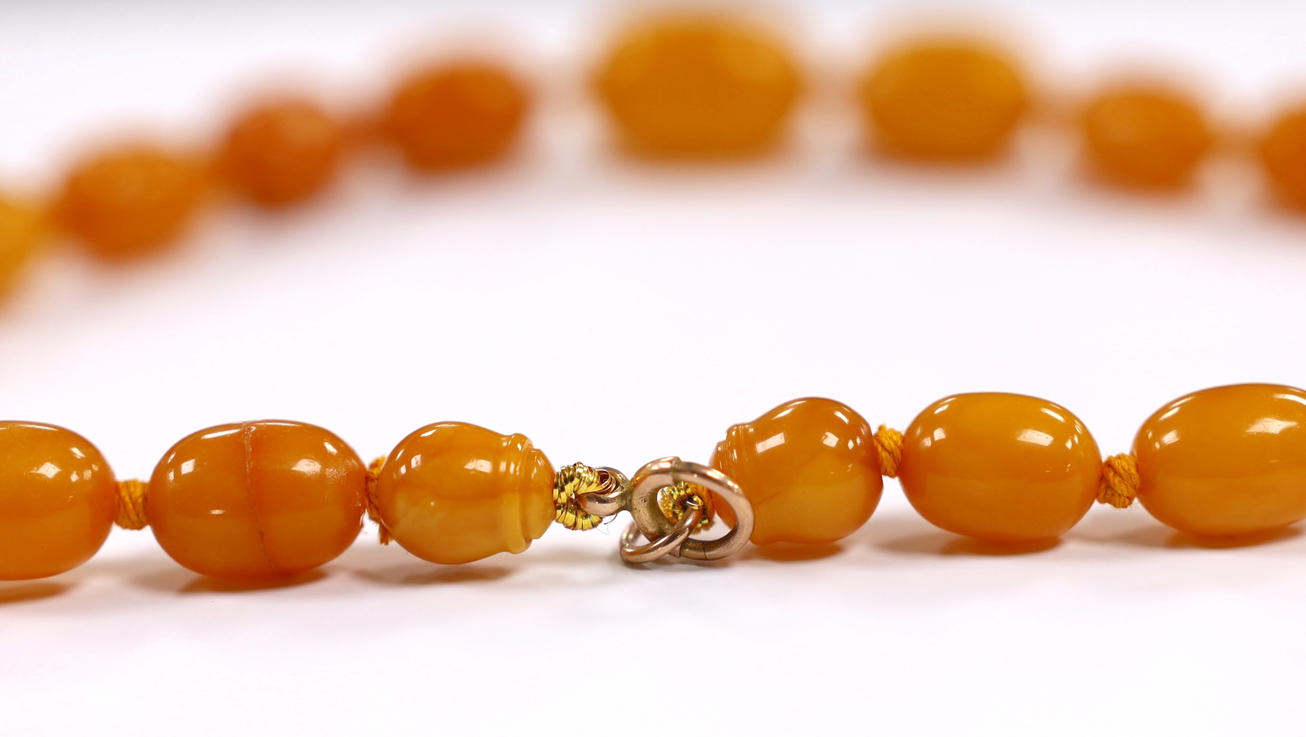 A single strand graduated amber bead necklace, with a 9ct clasp, 41cm, gross weight 43 grams.